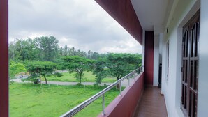 A balcony with a view of a green landscape and trees. - Coorg Residency Homestay (Somvarpet)