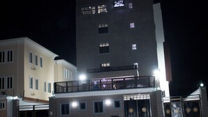 A hotel with a modern design, featuring a prominent balcony on the upper floor and a ground-level entrance with a sign displaying the number 2417. - Luxury Hotel Deluxe Room - Sleeps 2 - Gym - Pool (Lekki)