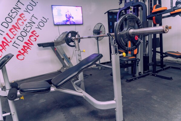 A gym with weightlifting equipment, a bench, and motivational wall text. - Luxury Hotel Deluxe Room - Sleeps 2 - Gym - Pool (Lekki)