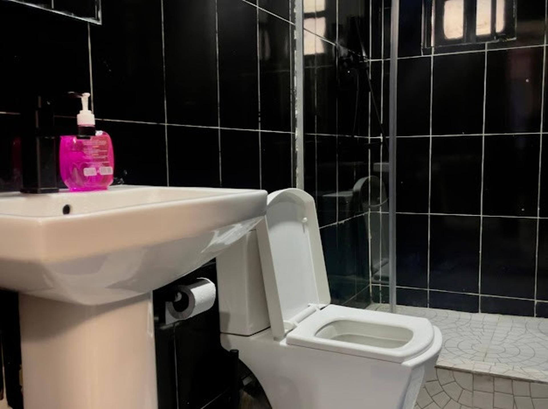 Ein Badezimmer mit Waschbecken, Toilette und Duschbereich.
