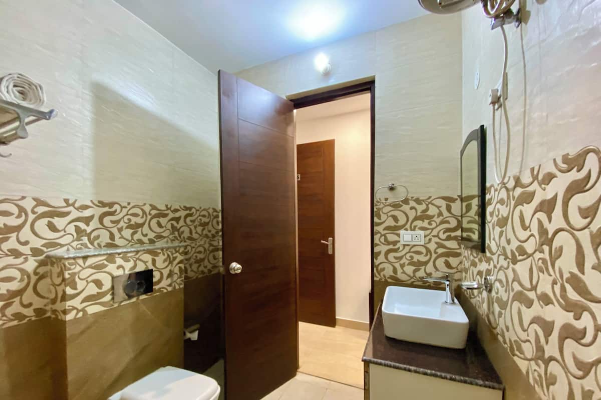 A bathroom with a toilet, sink, and shower.