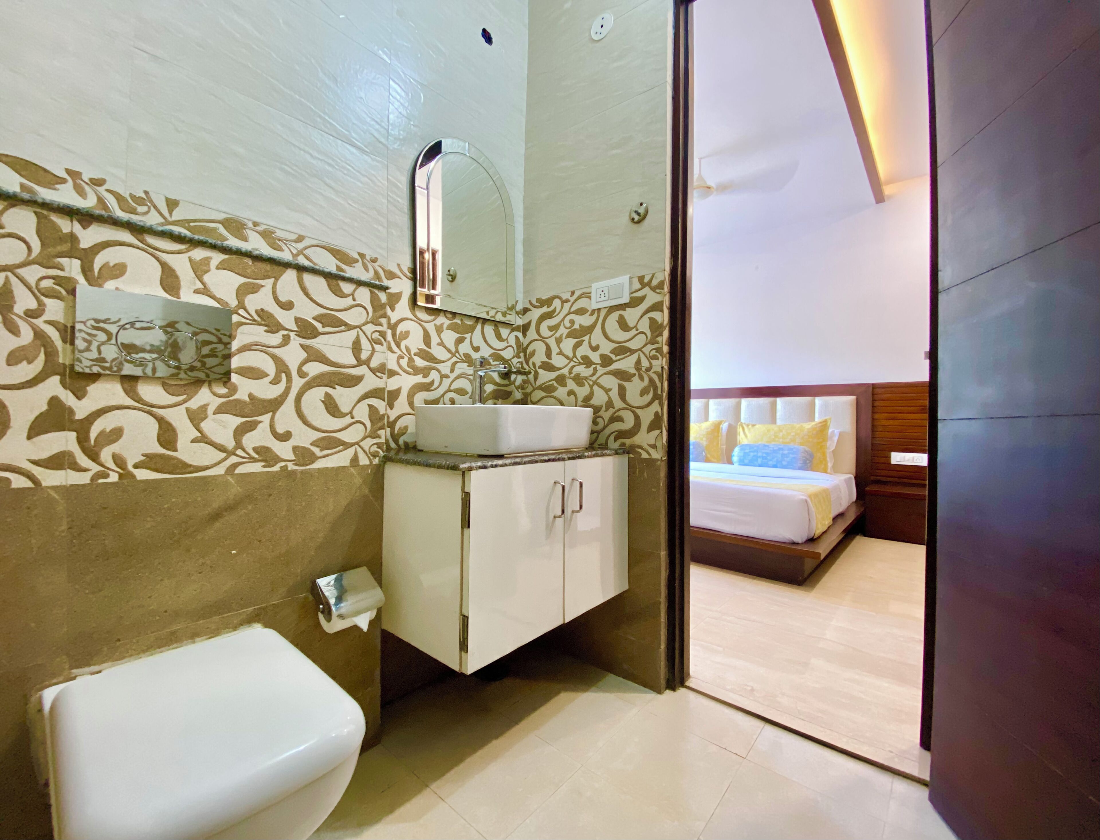A bathroom with a toilet, sink, and mirror.