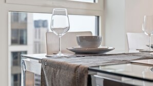 Una mesa de comedor con un vaso de agua, un tazón y un plato.
