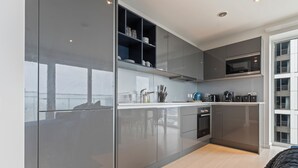 Una cocina moderna con armarios elegantes, un microondas integrado y una cafetera.