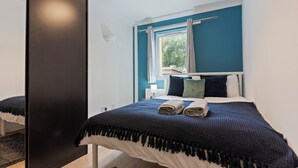 A bedroom with a bed, a window, and a mirror. - Cozy London Townhouse With 4 Bedrooms (London)