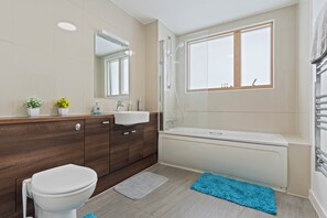 A modern bathroom with a toilet, sink, and bathtub. - Retreat Private Rooftop 3 Bedroom Apartment (London)