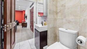A modern bathroom with a toilet, sink, and shower area. - London Chic Apartment - City Center Gem (London)