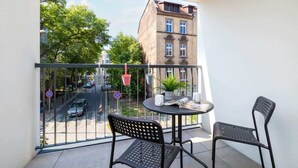 A balcony with two chairs, a small table, and a potted plant.