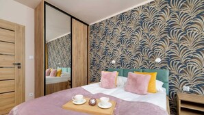 A modern bedroom with a bed, bedside tables, and a mirror.