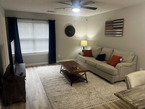 A living room with a sofa, coffee table, and a TV stand.