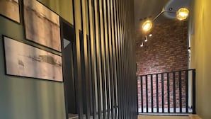 A staircase with black marble steps, a wooden railing, and a brick wall in the background. - Twelve Inn Hotel (Baku)