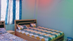 Ein Schlafzimmer mit zwei Betten, einem Deckenventilator und einem Fenster mit Vorhängen.