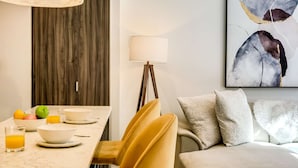 A modern dining area with a marble table, yellow chairs, and a white lamp. - Contemporary Comfort at City Suite 905 (Cape Town)