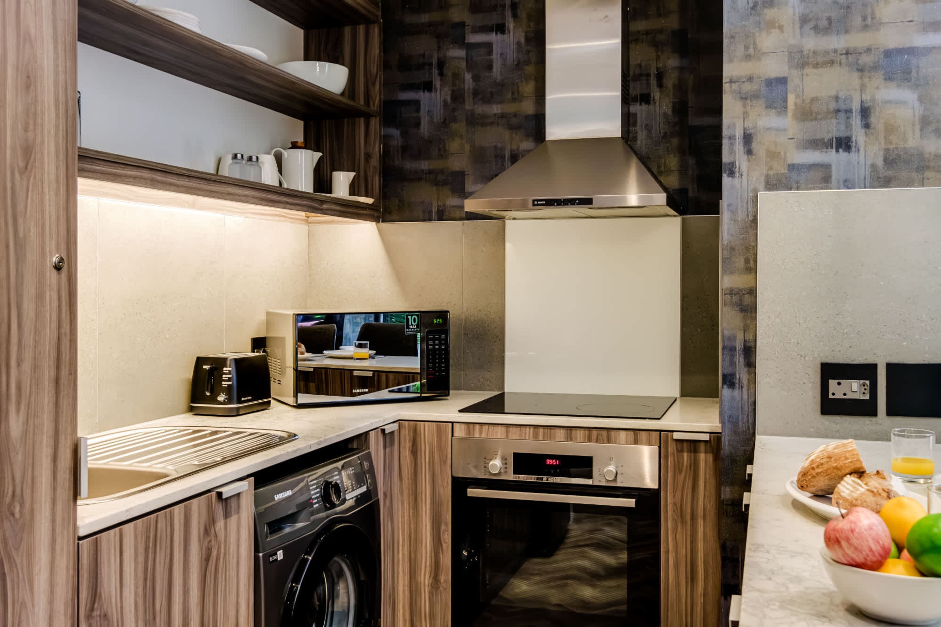 Una cucina compatta con microonde, tostapane e forno.