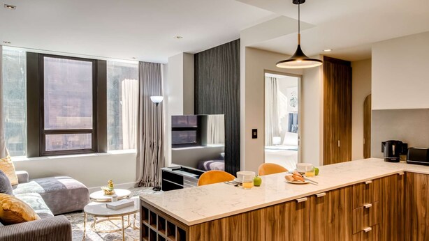 A modern apartment with a kitchen, dining area, and living room. It features large windows, a TV, and a coffee machine. - Upscale Urban Haven at City Suite 906 (Cape Town)