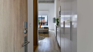 A modern kitchen with stainless steel appliances, a wooden door, and a view to the outside. - w Amazing Loft w Balcony in Chapinero (Bogotá)