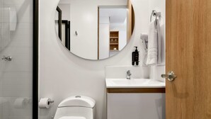 A modern bathroom with a toilet, sink, and mirror. - w Amazing Loft w Balcony in Chapinero (Bogotá)