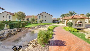 A courtyard with a brick pathway, a small water feature, and buildings with red-tiled roofs. - Quiet Condo w/ Pool Access, Near Arizona Boardwalk (Scottsdale)