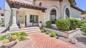 A stucco building with a tiled roof, a covered patio, and a well-maintained garden with cacti and shrubs. - Quiet Condo w/ Pool Access, Near Arizona Boardwalk (Scottsdale)