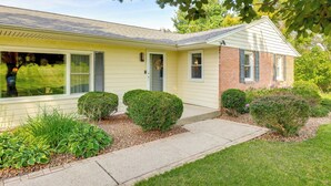 A two-story house with a front yard, a driveway, and a small garden with various plants. - 1440 Getaway w/ Yard & Deck ~ 16 Mi to Rochester (Rush)
