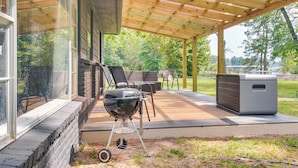 A covered patio with a grill, outdoor furniture, and a large air conditioning unit. - On-site Lake Access: Pet-friendly Vinita Home (Ketchum)