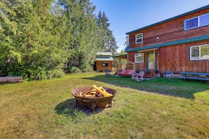 A wooden cabin with a covered porch, a fire pit, and a picnic table in a grassy yard surrounded by trees. - Cabin on 5 Acres in Port Angeles w/ Fire Pit! (Port Angeles)