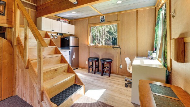 Ein Holzblock-Interieur mit einer Küche, einem Essbereich und einer Treppe.