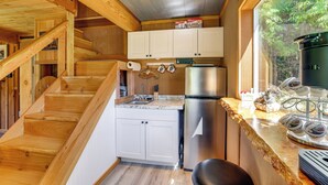 Eine Küche mit Holzausstattung, einem Edelstahlkühlschrank und einer Kaffeemaschine.