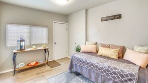 A bedroom with a bed, bedside table, and a wall-mounted sign.