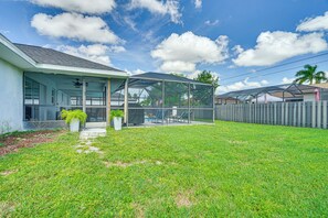 A house with a covered patio, a lawn, and a wooden fence. - Private Pool & Yard: Dog-friendly Cape Coral Home (Cape Coral)