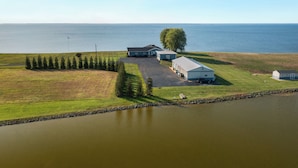 A large property with a main house, a smaller building, and a dock extending into a lake.