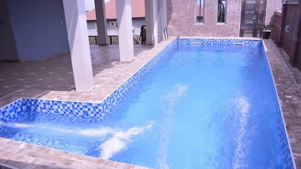 A rectangular swimming pool with blue tiles and a tiled deck surrounding it. - Camas Hotel and Suites (Abeokuta)