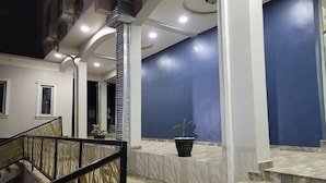 A modern interior with a marble staircase, a blue accent wall, and a black potted plant. - Camas Hotel and Suites (Abeokuta)
