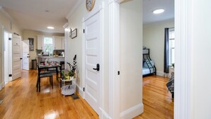 Una cocina amplia con armarios blancos, una mesa de comedor y un reloj en la pared.