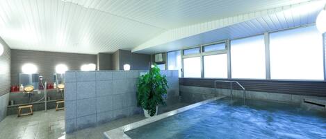 Une piscine avec une terrasse carrelée, un pot de fleurs et un espace douche équipé d’un miroir et de distributeurs de savon.