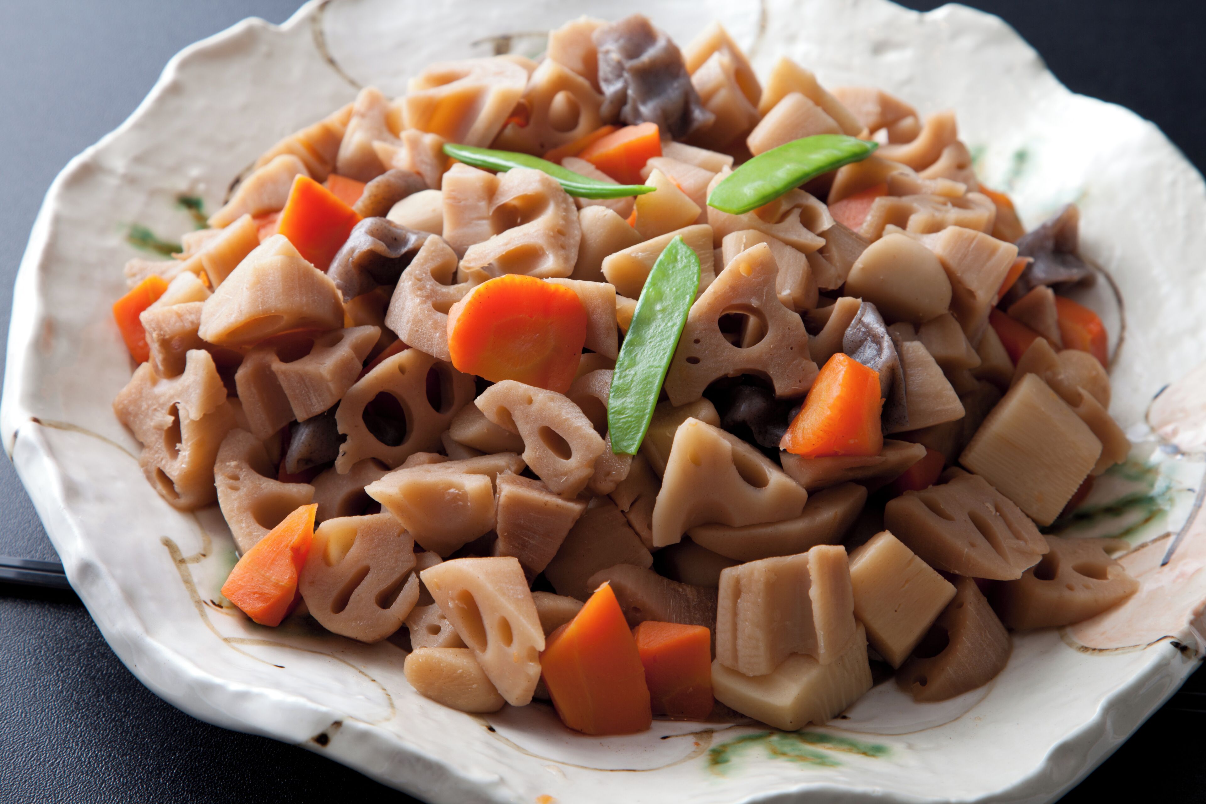 Een bord eten met verschillende groenten en stukjes tofu.