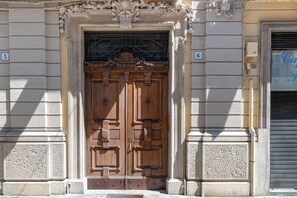 A double wooden door with intricate carvings, flanked by stone columns, and a sign with the number 6 above it. - 150mq Rooftop Paradise - Spacious Private Terrace (Bari)