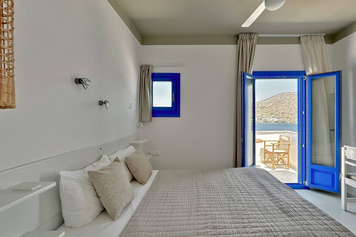A bedroom with a bed, a window, and a view of the outside.