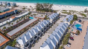 Ein Resort mit mehreren Gebäuden, einem Strand und einem Schwimmbad.