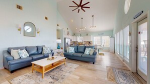 A living room with two sofas, a coffee table, and a kitchen in the background.