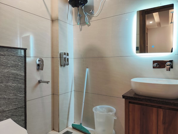 A modern bathroom with a shower, sink, and mirror. - HOTEL VAIDIK GANGA (rishikesh)
