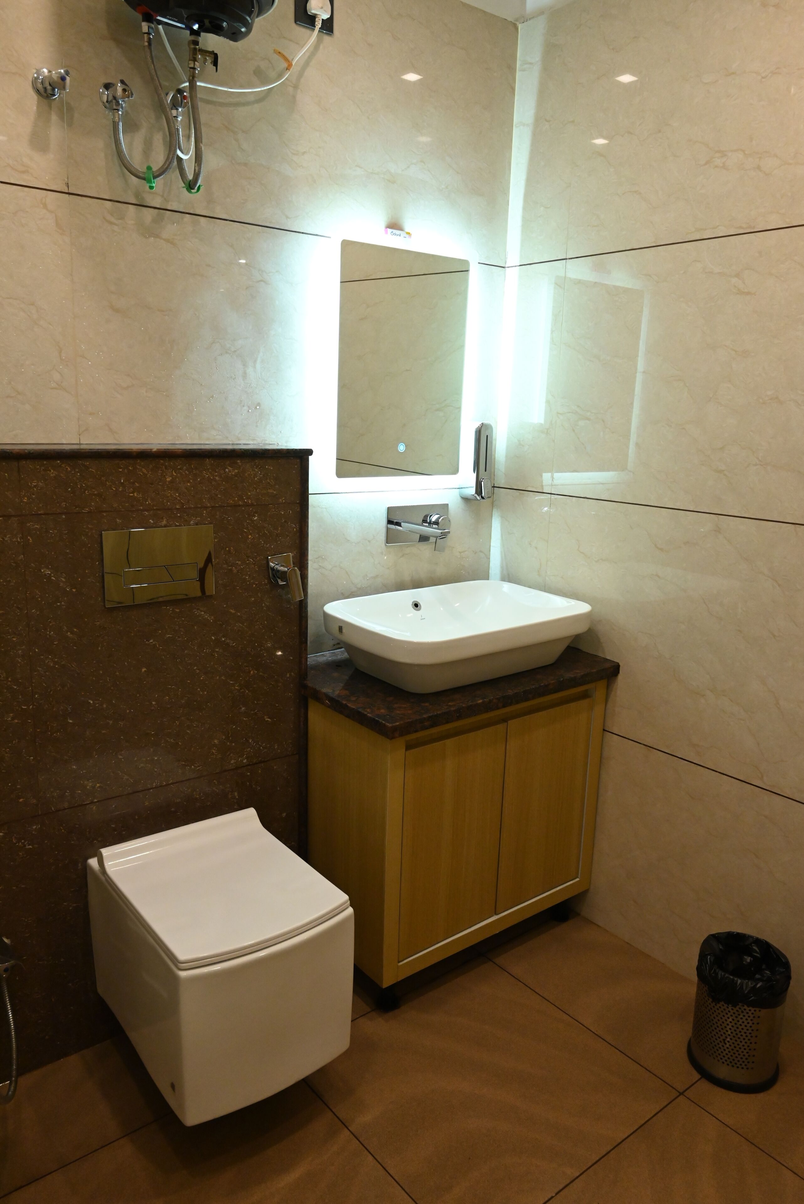 Un baño moderno con inodoro blanco, un lavamanos con espejo y zona de ducha.