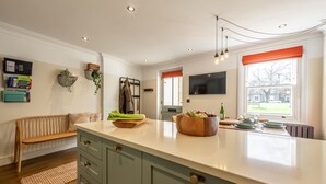 Une cuisine moderne dotée d’un grand îlot central, de meubles en bois et d’un four encastré.