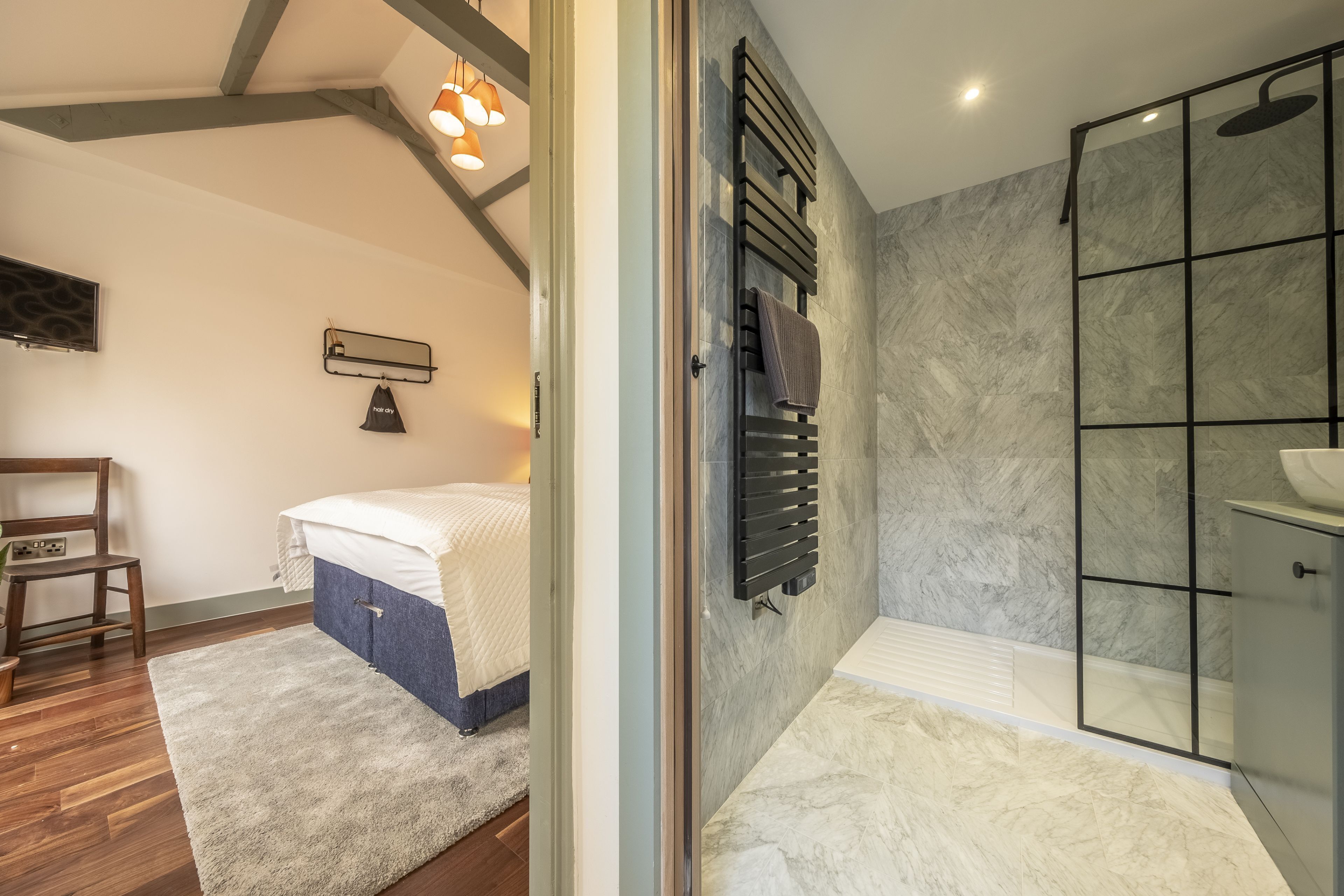 A modern bathroom with a glass shower enclosure, a built-in sink, and a towel rack.