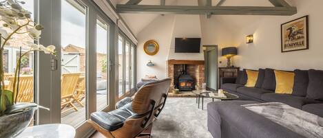 A spacious living room with a fireplace, a large window, and a cozy seating area.