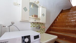 A compact bathroom with a washing machine, a sink, and a mirror above the mirror cabinet. - 4187 Casa Elen by Barbarhouse (Ostuni)