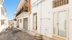 A narrow street with buildings on both sides, closed shutters, and a clear sky. - 4187 Casa Elen by Barbarhouse (Ostuni)