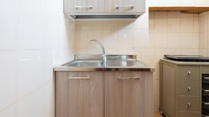 A kitchen with a stainless steel sink, wooden cabinets, and a built-in oven. - 4187 Casa Elen by Barbarhouse (Ostuni)