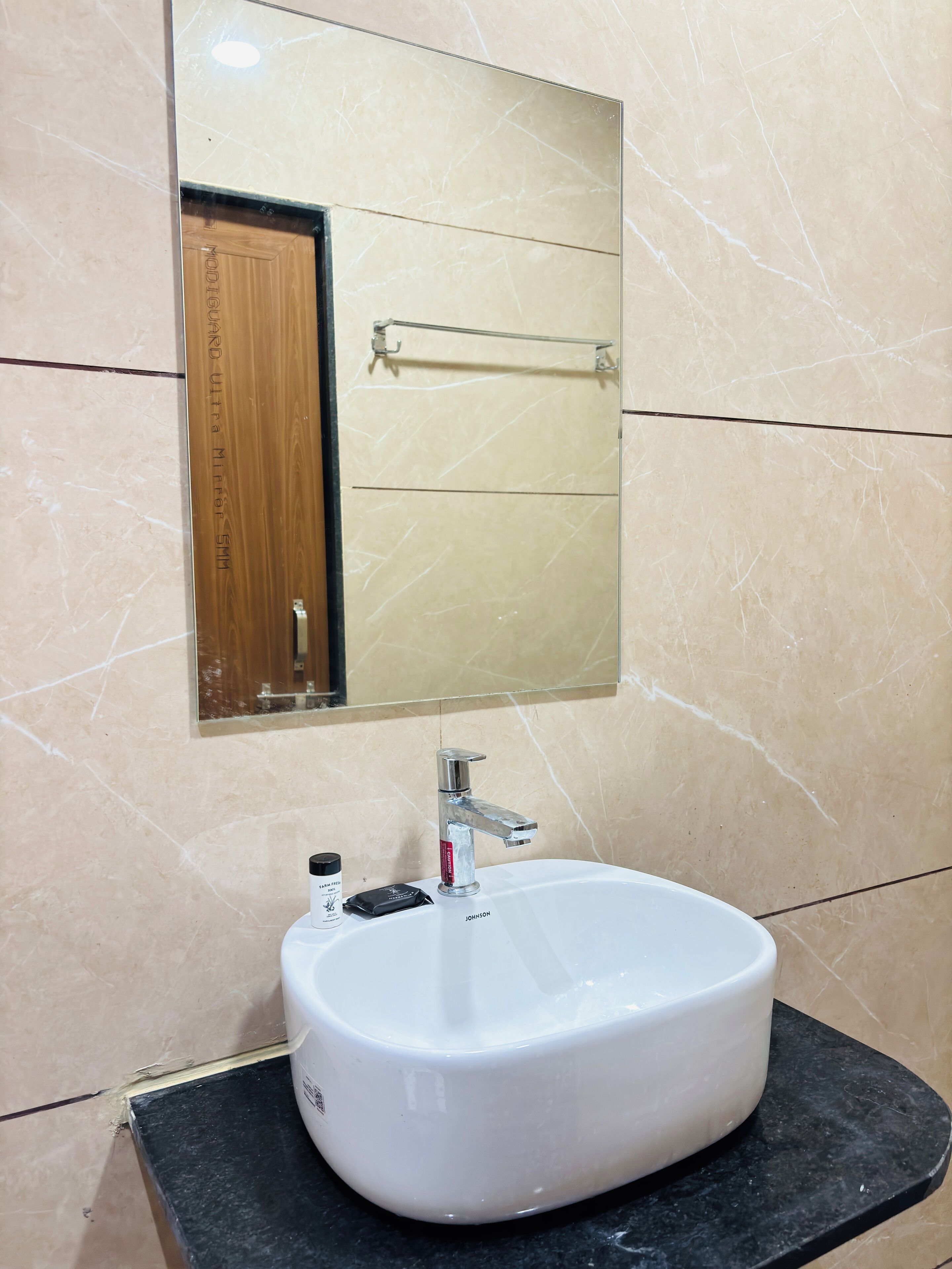 Une salle de bain avec un lavabo blanc, un miroir et un porte-serviettes.