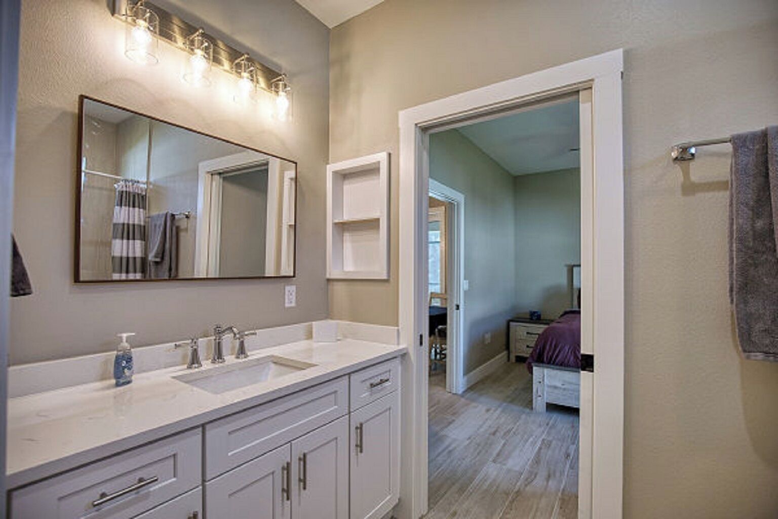 A bathroom with two sinks, a large mirror, and a shower area.